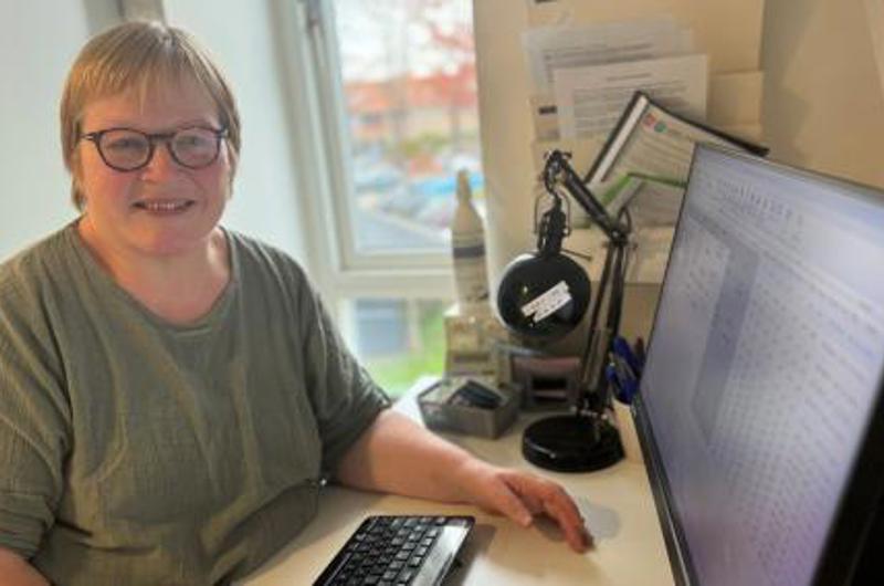ATP medarbejder Inge Henning smiler ved computer